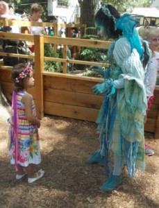 Blue green fairy fascinated by someone else at the faire.